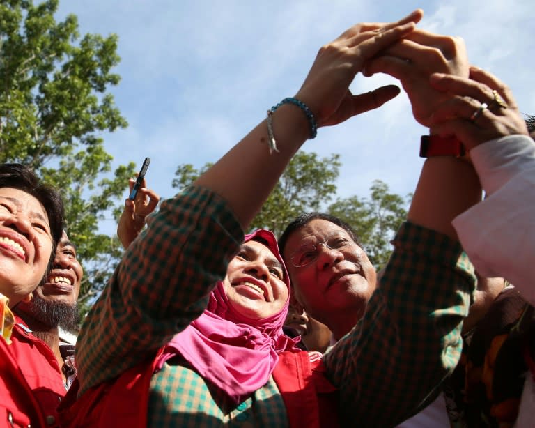 Philippines President Rodrigo Duterte (R) poses for photos with residents affected by the armed conflict, during a visit to Isabela town, Basilan province, on southern island of Mindanao on July 21, 2016