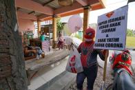 Man donning superhero costume brings cheer to children confined to their homes by COVID-19 restrictions in Sukoharjo