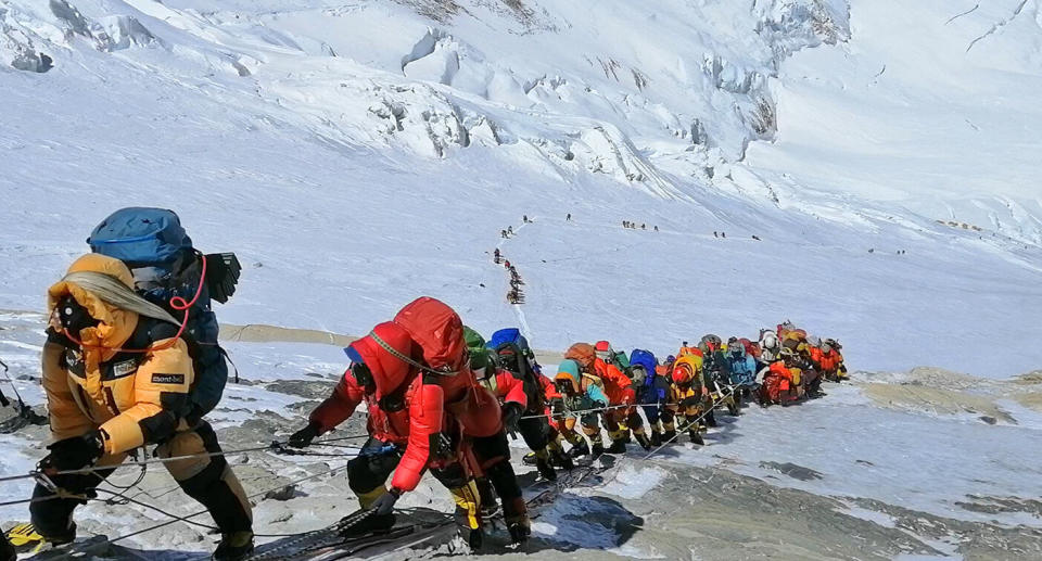 Dozens of mountaineers snake up Mount Everest during the crowded season.