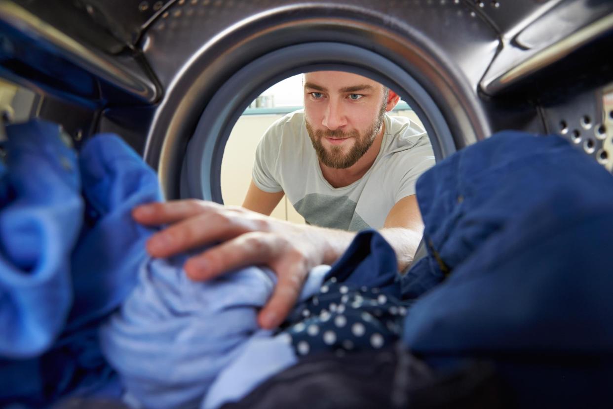 man getting clothes out of the dryer