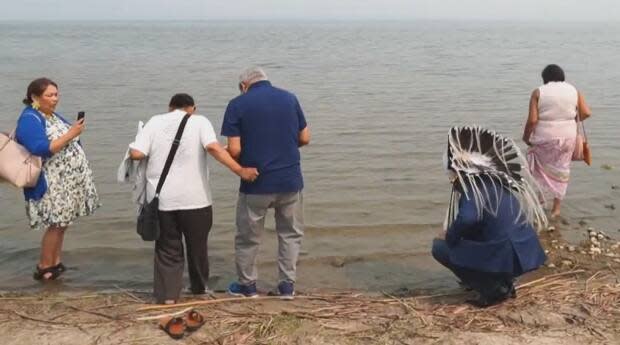 While the annual pilgrimage is being held virtually this year, pilgrims who choose to journey to Lac Ste. Anne to bathe in its waters aren’t being turned away.  (Catholic Archdiocese of Edmonton/YouTube - image credit)