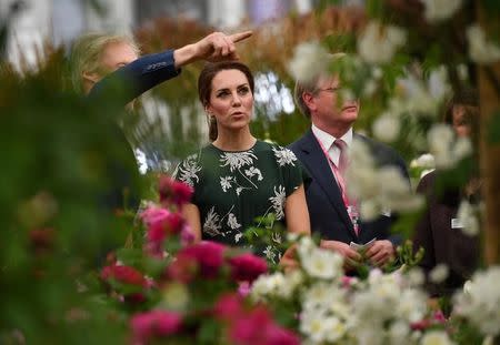 Britain's Catherine, Duchess of Cambridge (C) reacts as she views a display of David Austin roses at the Chelsea Flower Show in London on May 22, 2017. The Chelsea flower show, held annually in the grounds of the Royal Hospital Chelsea, opens to the public this year from May 22. REUTERS/Ben Stansall/Pool