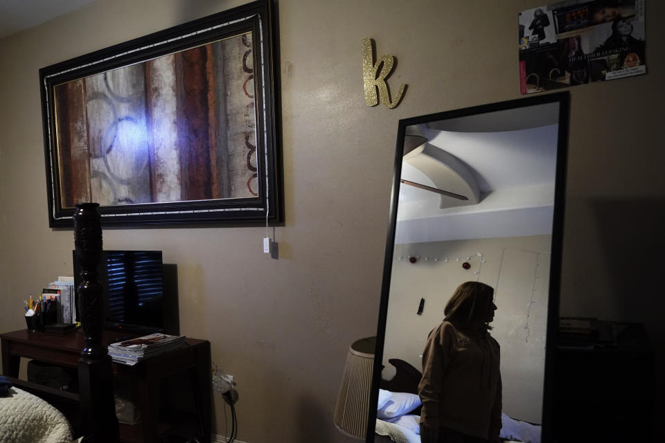Irma Reyes is reflected in the mirror of her daughter's room as she recalls the details of her daughter's ordeal with trafficking and the following trial at her South Texas home, Tuesday, Jan. 31, 2023. Reyes' daughter was one of two teens who men were accused of keeping at a San Antonio motel where other men paid to have sex with them in 2017. Their cases have seen years of delay, a parade of prosecutors, an aborted trial and, ultimately, a stark retreat by the government with the offer of a plea deal. (AP Photo/Eric Gay)