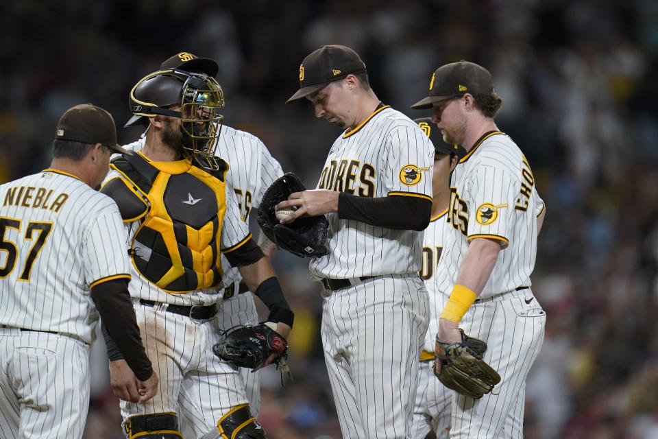 San Diego Padres starting pitcher Blake Snell, second from right, meets on the mound with teammates, including pitching coach Ruben Niebla, left, during the seventh inning of the team's baseball game against the St. Louis Cardinals, Wednesday, Sept. 21, 2022, in San Diego. (AP Photo/Gregory Bull)