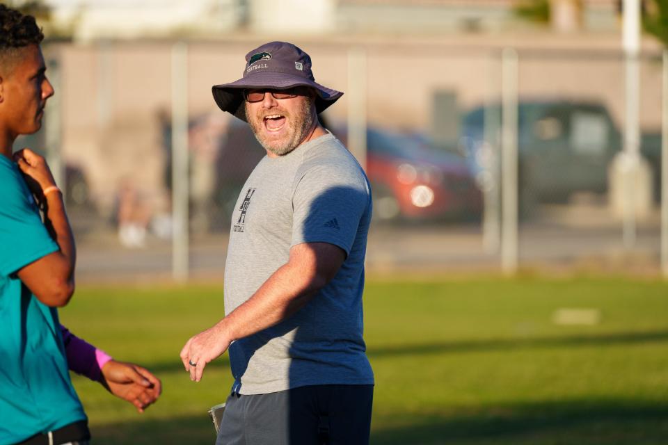 Head defensive coordinator, Jason Lyons (right) directs Highland football players at practice on Oct. 17, 2022, in Gilbert, Ariz.