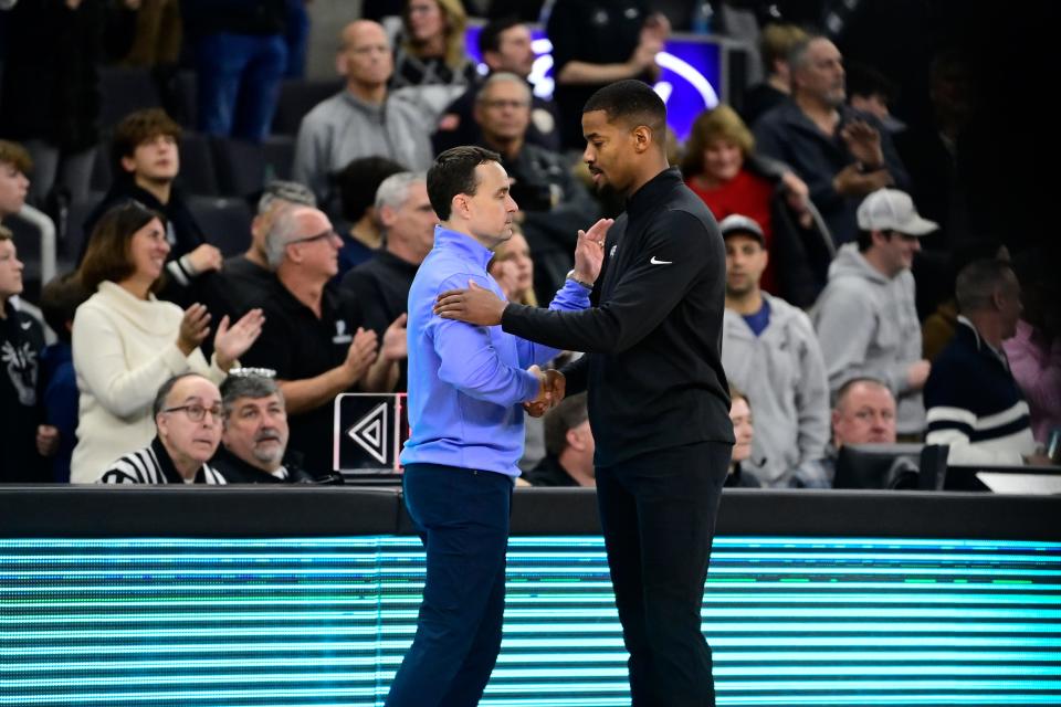 Rhode Island Rams head coach Archie Miller (left) and Providence Friars coach Kim English (right) shake hands after Saturday's game at Amica Mutual Pavilion. PC won, 84-69.