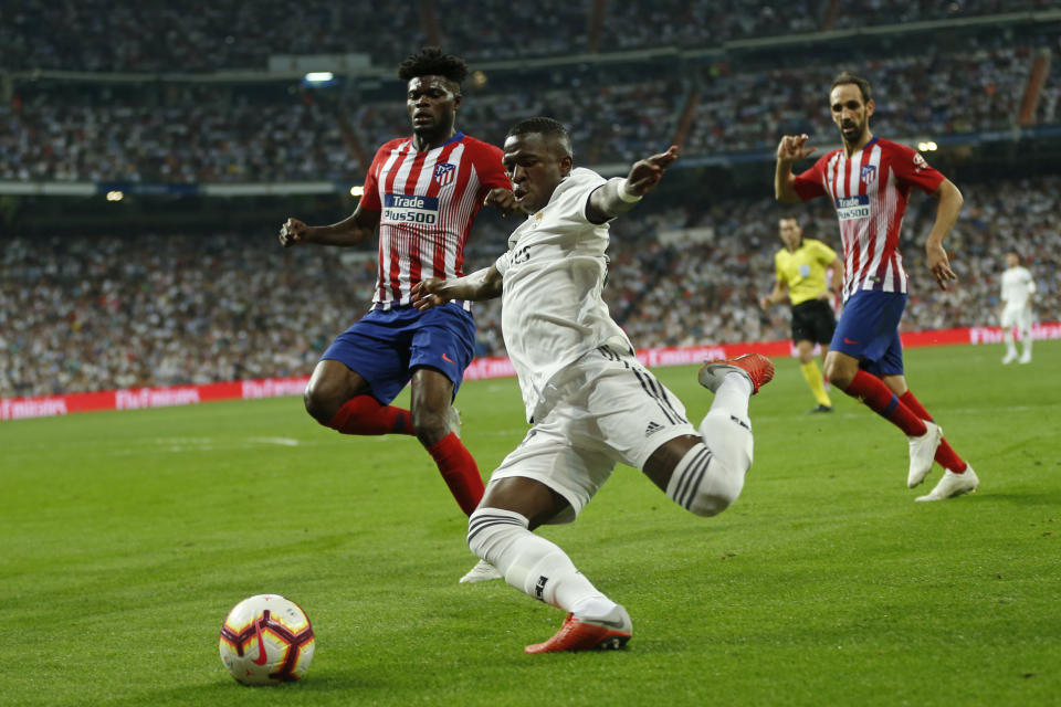 Real Madrid's Vinicius Junior, front, vies for the ball with Atletico Madrid's Thomas Partey, left, during a Spanish La Liga soccer match between Real Madrid and Atletico Madrid at the Santiago Bernabeu stadium in Madrid, Spain, Saturday, Sept. 29, 2018. The match ended in a 0-0 draw. (AP Photo/Paul White)