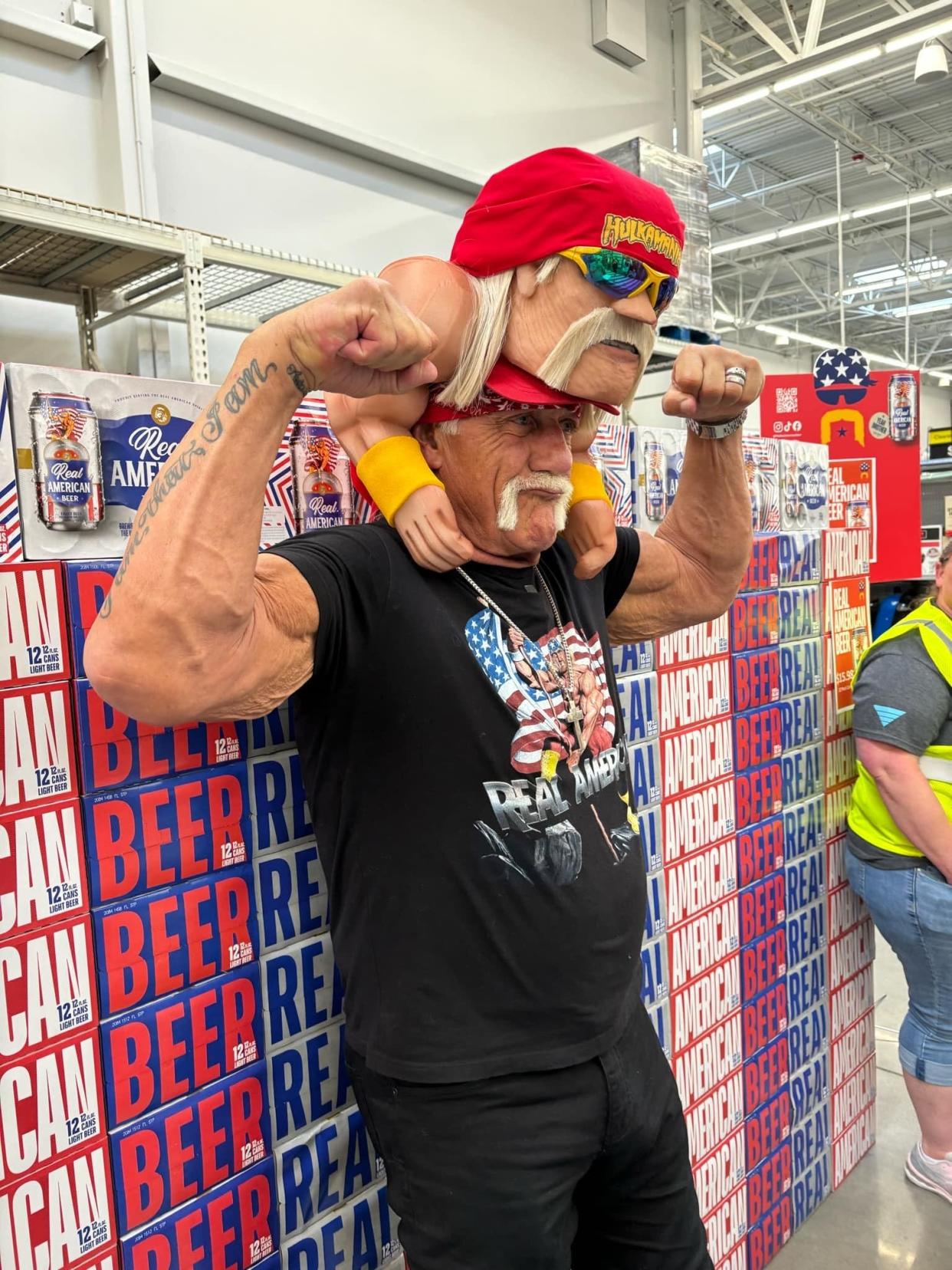 Hulk Hogan, whose real name is Terry Bollea, poses while wearing a hat bearing his likeness, made by Jeff Kahlow, of Fond du Lac, during an appearance at the Appleton Walmart on Aug. 7, 2024.