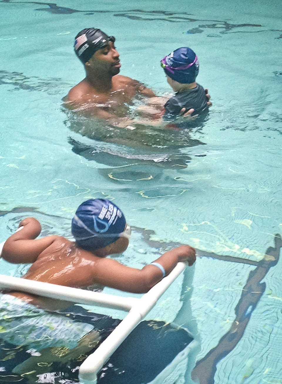 This May 17, 2013 photo released by Simone Smalls PR shows Olympic gold medalist Cullen Jones give swimming lessons to students at Harlem's P.S. 125 in New York. Jones is ambassador for the 5th Annual USA Swimming Foundation's "Make a Splash Tour," providing free swimming lessons, water safety education and awareness at city pools. (AP Photo/Simone Smalls PR)