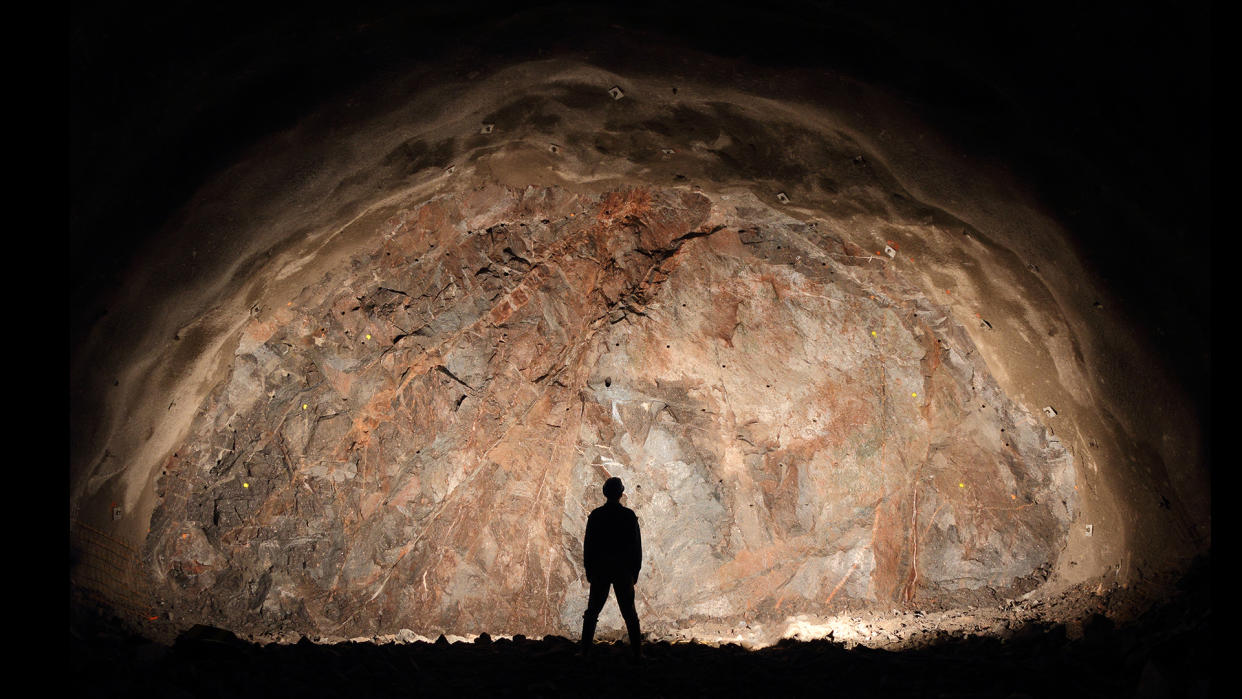  Mine, tunnel front, silhouette of a standing worker. 