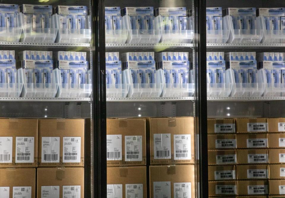 Glass-doored refrigerators filled with packages of insulin, some in brown shipping boxes