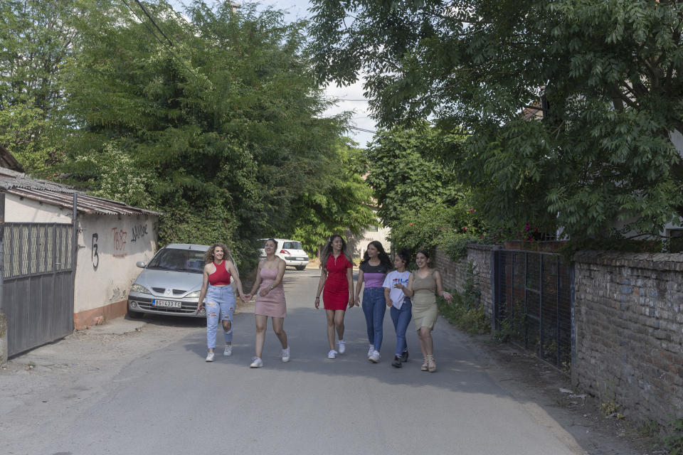 From left, Silvia Sinani, 24, Dijana Ferhatovic, 18, Zivka Ferhatovic, 20, Elma Dalipi, 14, Selma Dalipi, 14, and Zlata Ristic, 27, members of the Pretty Loud band, walk along a street in their neighborhood in Belgrade, Serbia, Wednesday, June 16, 2021. A female Roma, or Gypsy, band in Serbia has used music to preach women's empowerment within their community. Formed in 2014, “Pretty Loud” symbolically seeks to give a louder voice to Roma girls, encourage education and steer them away from the widespread custom of early marriage. (AP Photo/Marko Drobnjakovic)