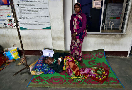 The wife of a tea plantation worker, who consumed bootleg liquor, looks on as she stands next to her husband being treated, in a corridor of a government-run hospital in Golaghat in Assam, India, February 23, 2019. REUTERS/Anuwar Hazarika