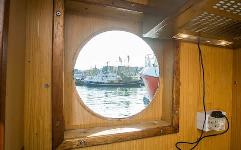 A smashed window onboard of Golden Promise at the Brixham Harbour in Devon, which was smashed by a rock thrown by french fishermen - Credit: SWNS.com 