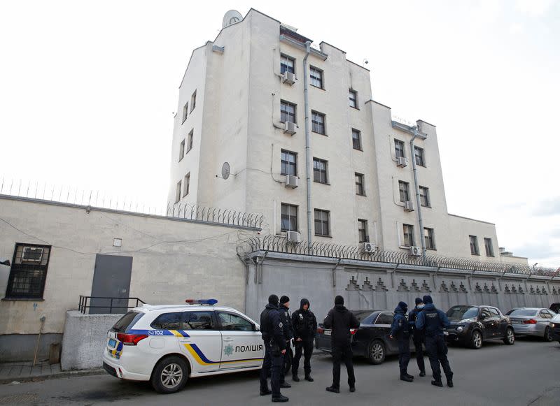 Police officers and members of the Ukrainian National Guard are seen outside the Russian embassy in Kyiv