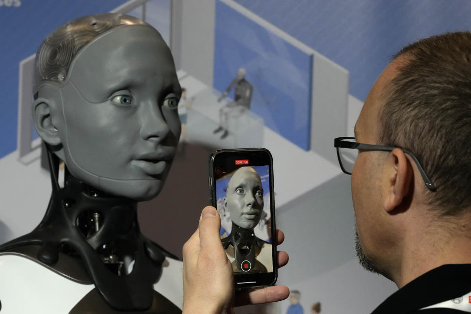 A robot that looks like a human head designed by AMECA, interacts with visitors during the International Conference on Robotics and Automation ICRA in London, Tuesday, May 30, 2023.The 2023 ICRA brings together the world's top academics, researchers, and industry representatives to show the newest developments. Ameca is a humanoid robot platform for human-robot interaction. (AP Photo/Frank Augstein)