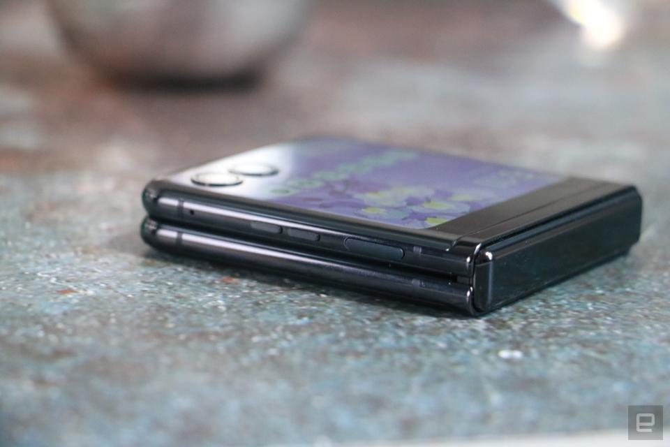 <p>An off angle view of the Moto Razr+ folded shut and laying flat on a table with its outside screen facing up.</p> 