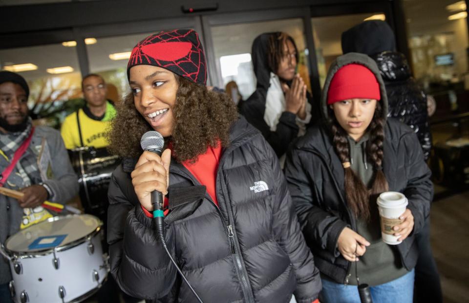 Jailynn Butler-Thomas speaks into a microphone at an outdoor demonstration.