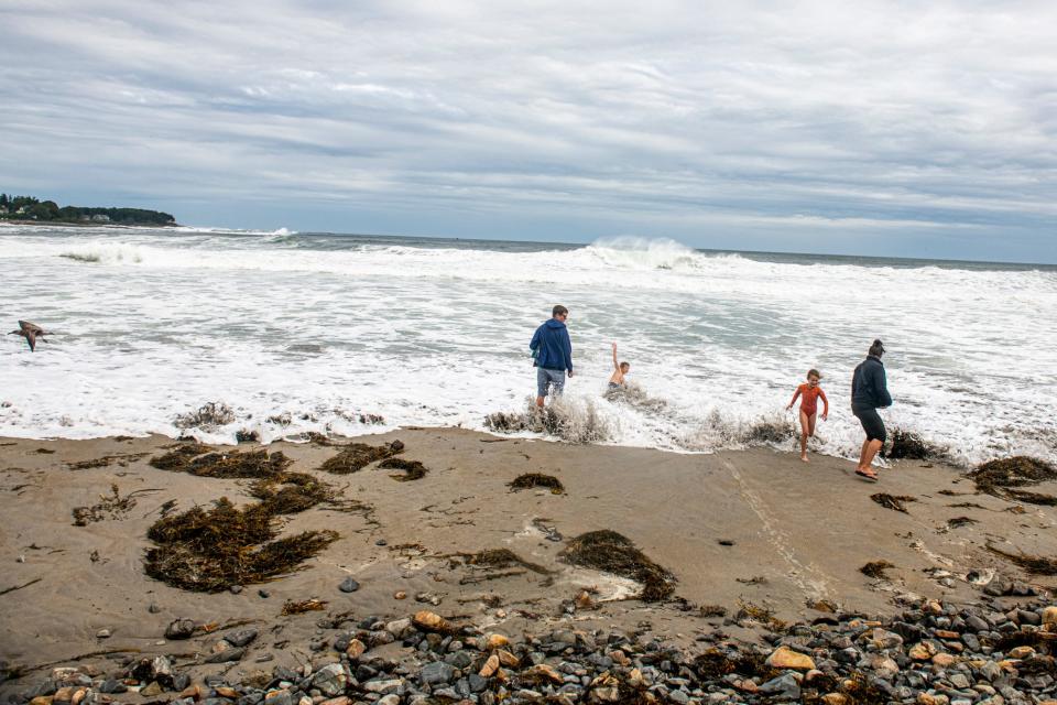 Scott Brandt, left, his wife Jenny Brandt and children, Jayce and Juno, play in high waves on Short Sands beach in York, Maine, during Hurricane Lee on Saturday, Sept. 16, 2023. The Brandt family are visiting New England from Northern California for a wedding.