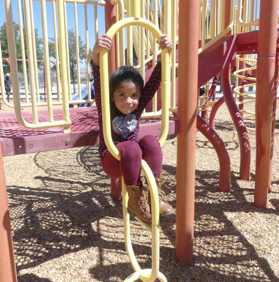 The daughter of Fabiola Gomez enjoys the playground equipment at Mojave Vista Park in Victorville.