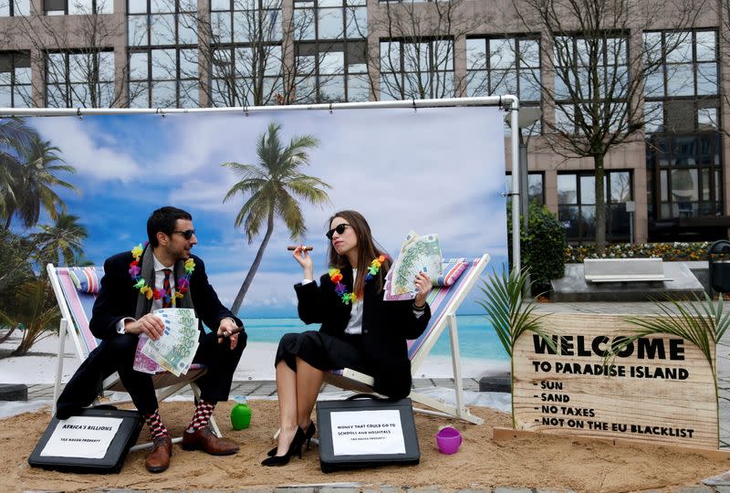 FILE PHOTO: Activists stage a protest on a mock tropical island beach representing a tax haven outside a meeting of European Union finance ministers in Brussels