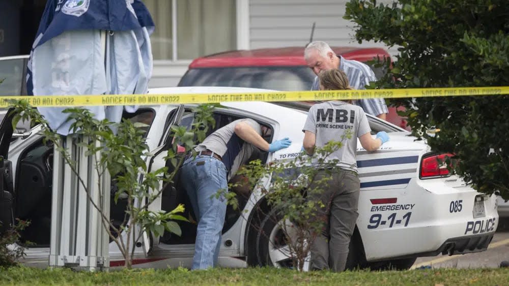 Investigators at the crime scene following the incident. (AP)