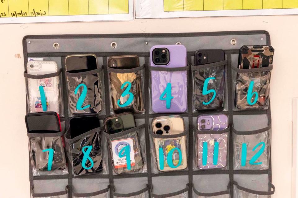 Phones sit in a caddy in Kyanna McCall’s seventh-grade classroom at Rolesville Middle School on March 27.