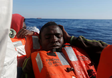 A migrant reacts after being rescued from a rubber dinghy by the Malta-based NGO Migrant Offshore Aid Station (MOAS) in the central Mediterranean in international waters some 15 nautical miles off the coast of Zawiya in Libya, April 14, 2017. REUTERS/Darrin Zammit Lupi