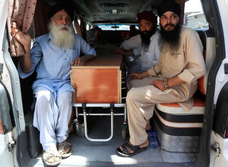Afghan Sikh men sit next to the coffin of one of the victims of yesterday's blast in Jalalabad city, Afghanistan July 2, 2018. REUTERS/Parwiz