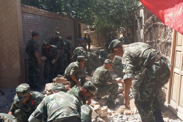 Rescuers help villagers clear the debris after the quake in Pishan county, in northeast China's Xinjiang region on July 3, 2015, which measured 6.4 on the Richter scale