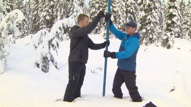 Metro Vancouver field hydrologist Peter Marshall and CBC meteorologist Brett Soderholm push a snowpack measuring tool into the snow. New technology is helping provide a clearer picture of the region’s drinking water supply.