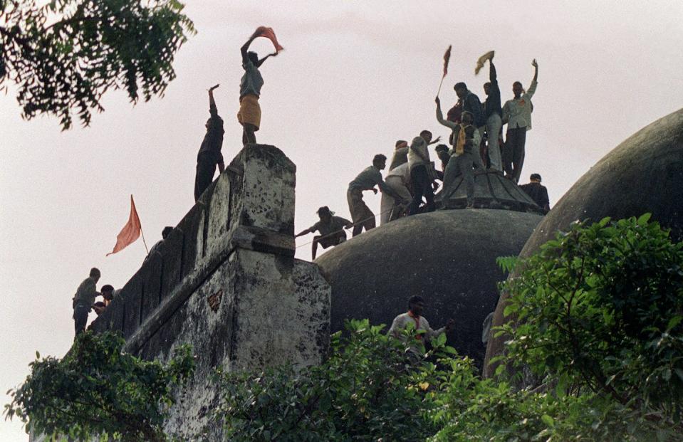 People atop the 16th century Babri mosque before the structure was demolished in 1992. <a href="https://www.gettyimages.com/detail/news-photo/in-this-file-photograph-taken-on-december-6-1992-hindu-news-photo/88756585?adppopup=true" rel="nofollow noopener" target="_blank" data-ylk="slk:Douglas E. Curran/AFP via Getty Images;elm:context_link;itc:0;sec:content-canvas" class="link ">Douglas E. Curran/AFP via Getty Images</a>