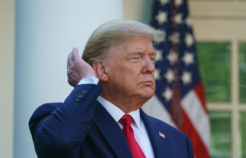 President Donald Trump pats down his hair as he speaks during the Coronavirus Task Force daily briefing on COVID-19 in the Rose Garden. (MANDEL NGAN via Getty Images)