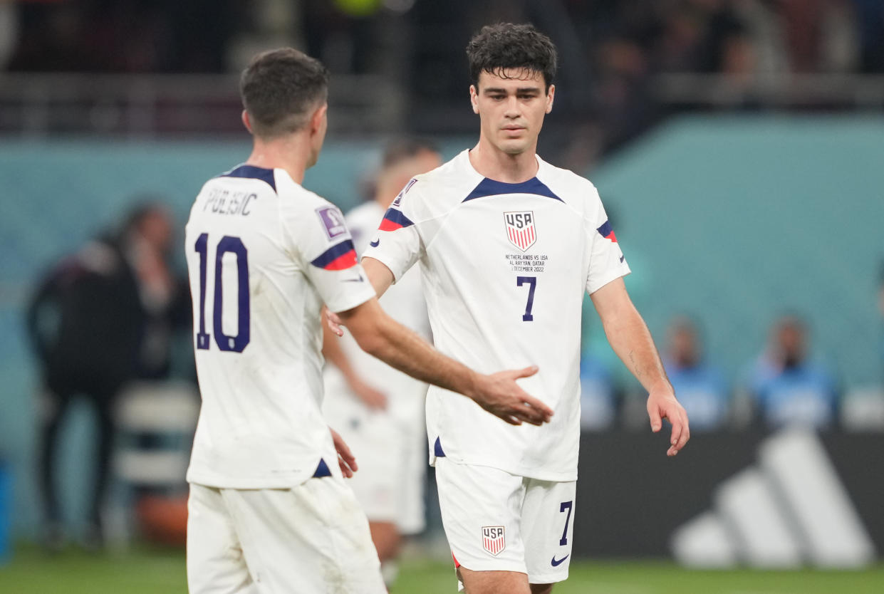 DOHA, QATAR - DECEMBER 3: Christian Pulisic #10 and Gio Reyna #7of the United States find solis with one another after their loss to the Netherlands after a FIFA World Cup Qatar 2022 Round of 16 match between Netherlands and USMNT at Khalifa International Stadium on December 3, 2022 in Doha, Qatar. (Photo by John Todd/ISI Photos/Getty Images)