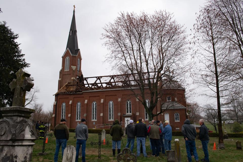 People examine the exposed structure of St. Joseph Catholic Church at 6202 W St. Joseph Road after the roof peeled away from the high winds that swept through Vanderburgh County Friday afternoon, March 3, 2023.