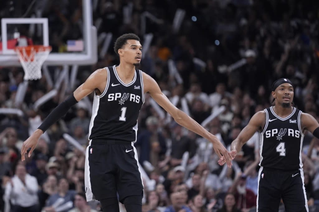 San Antonio Spurs center Victor Wembanyama (1) celebrates a score with guard Devonte’ Graham (4) during the second half of an NBA basketball game against the Denver Nuggets in San Antonio, Friday, April 12, 2024. (AP Photo/Eric Gay)