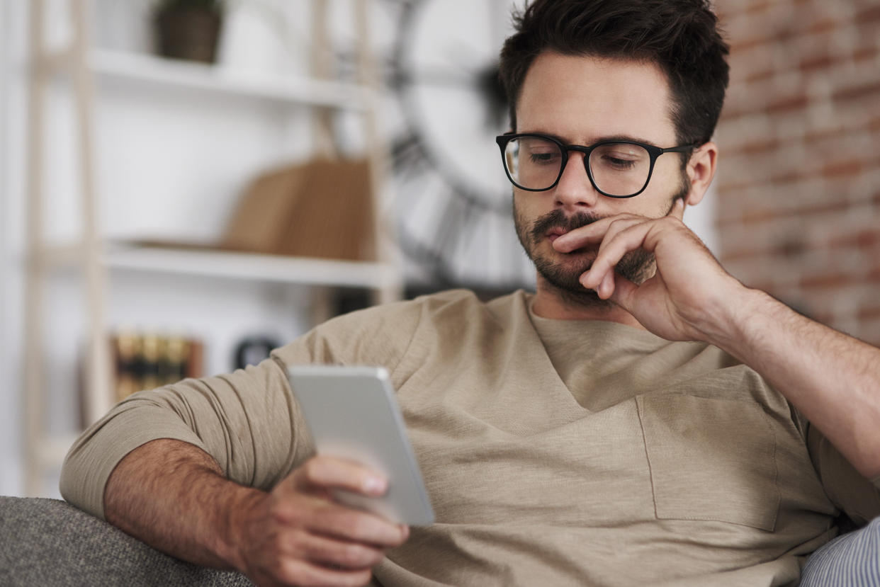 Man looking at health information on phone, looking concerned. (Getty Images)