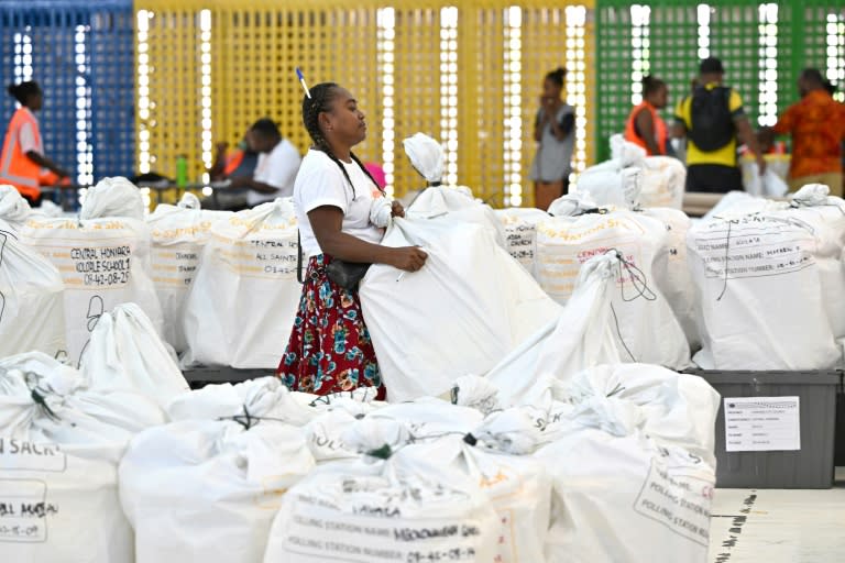 Una funcionaria electoral lleva una urna con papeletas en un centro de recuento de votos en Honiara, capital de las Islas Salomón, el 18 de abril de 2024, al día siguiente de las elecciones generales (Saeed Khan)