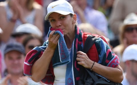 Simona Halep grabs her towel and slopes off out of Wimbledon - Credit: AFP