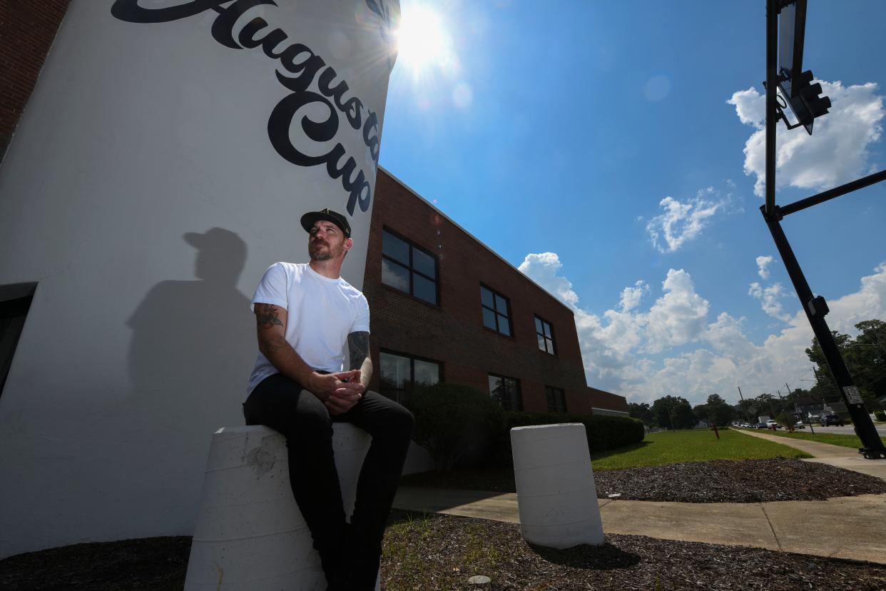 Addison Niday poses for a portrait in front of his mural “Augusta Cup” off Wrightsboro Road on Tuesday, Aug. 15, 2023. 