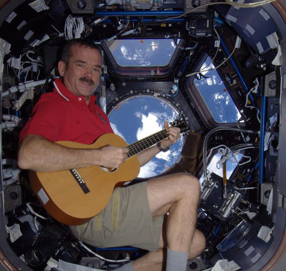 Canadian astronaut Chris Hadfield strums a guitar while playing Christmas carols and gazing at Earth from the International Space Station in December 2012.