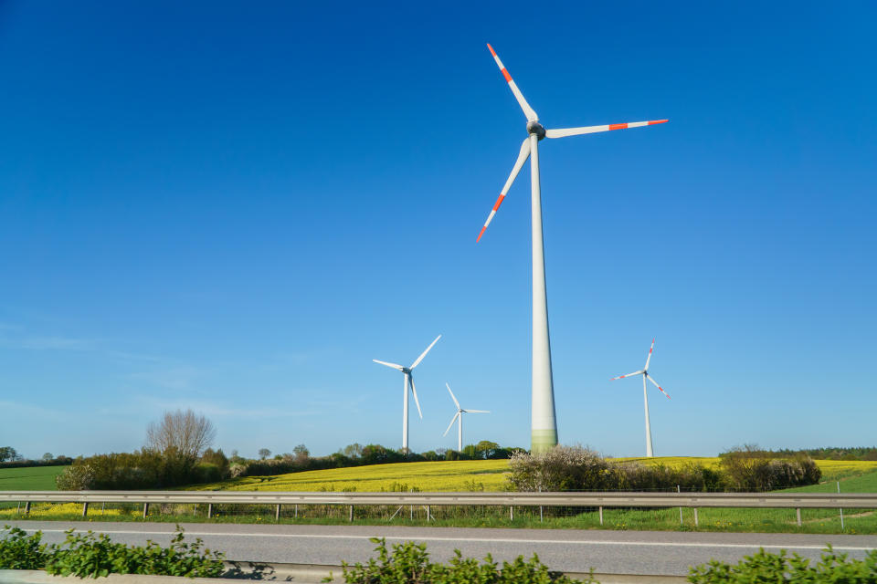 Windmills, Many wind turbines standing on field with lush green grass in spring, alternative energy sources