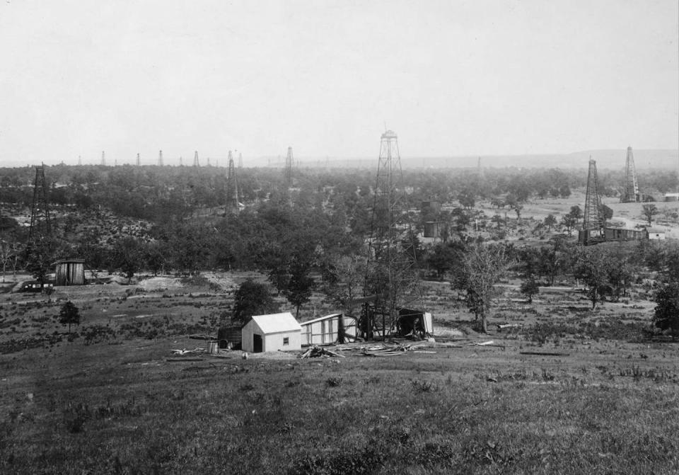 Black and white photo of oil derricks.