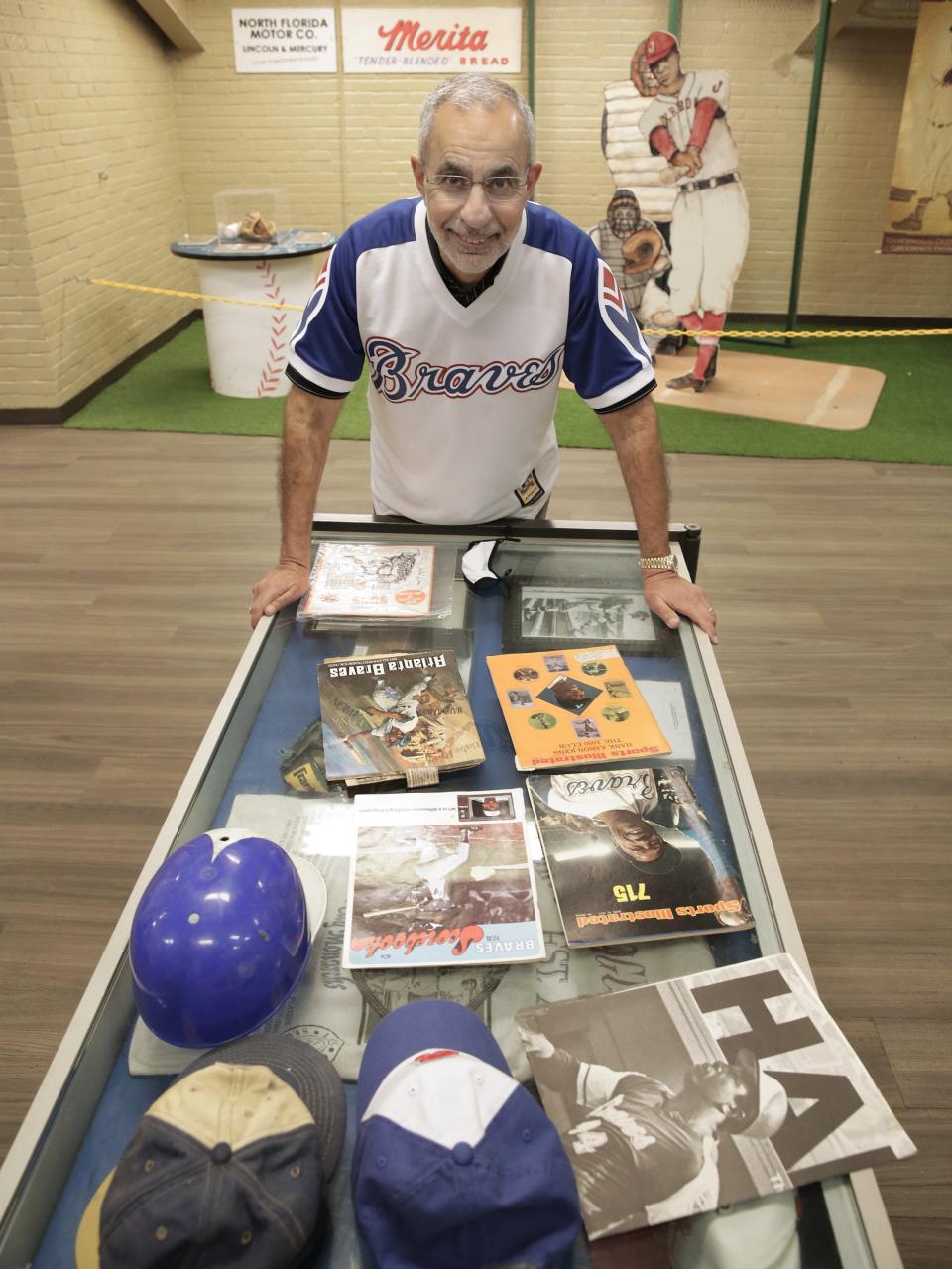 Ron Salem shows off some of his baseball memorabilia while visiting the museum at J.P. Small Memorial Stadium in the Durkeeville neighborhood in 2021. Salem, a lifelong fan of the Atlanta Braves and its Hall of Fame player Hank Aaron, successfully proposed to have the baseball field portion of the stadium named after Aaron who played a minor league season at the stadium in 1953.