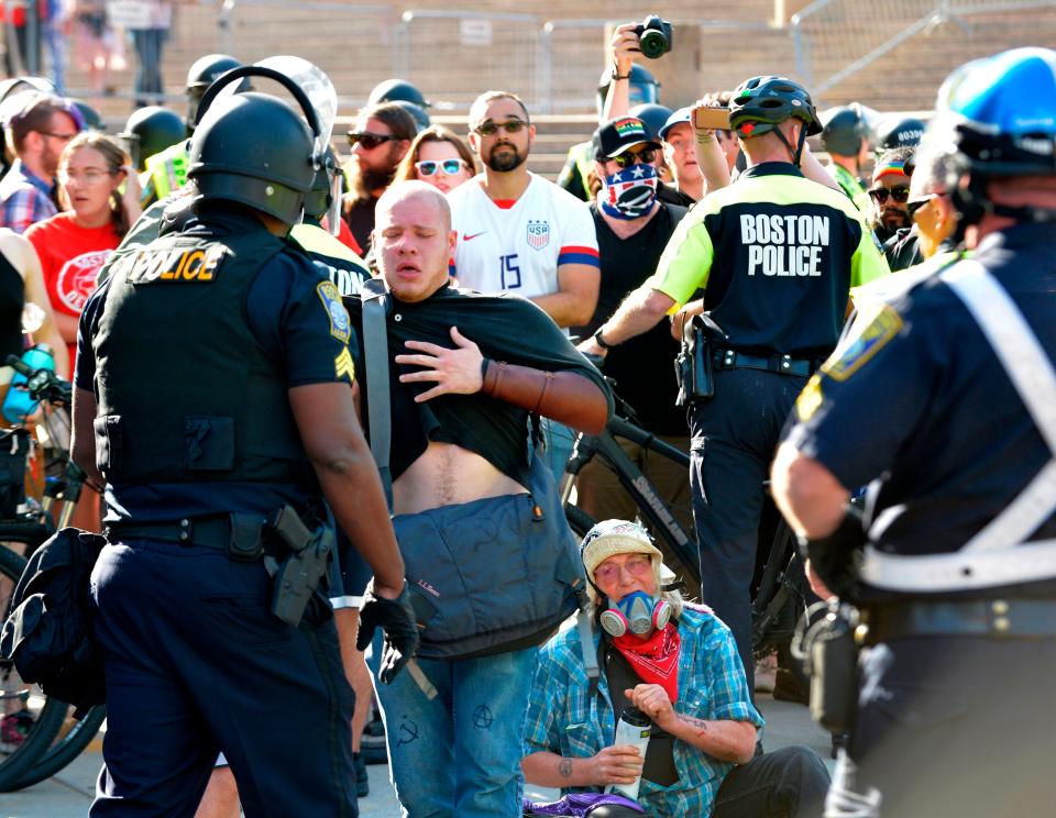 Protesters are overcome after police used pepper spray on anti-parade demonstrators during the 