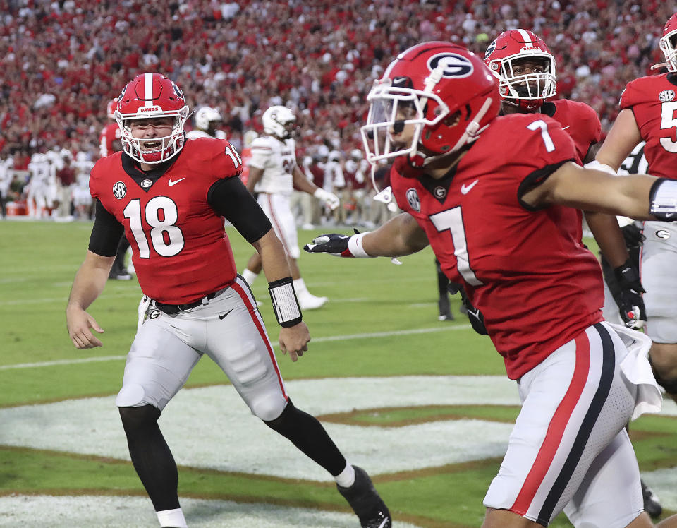 Georgia quarterback JT Daneils, left, and wide receiver Jermaine Burton celebrate after hooking up for a 43-yard touchdown pass against South Carolina during the first quarter in an NCAA college football game Saturday, Sept. 18, 2021, in Athens, Ga. (Curtis Compton/Atlanta Journal-Constitution via AP)