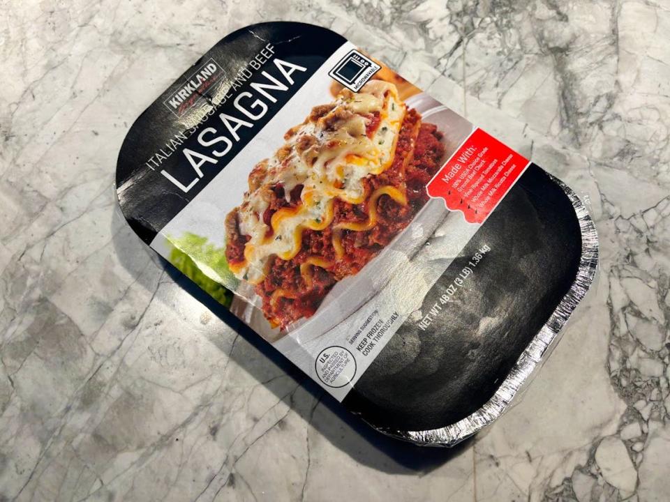 A black package with an image of lasagna, with distinctive layers, on a plate, on the box