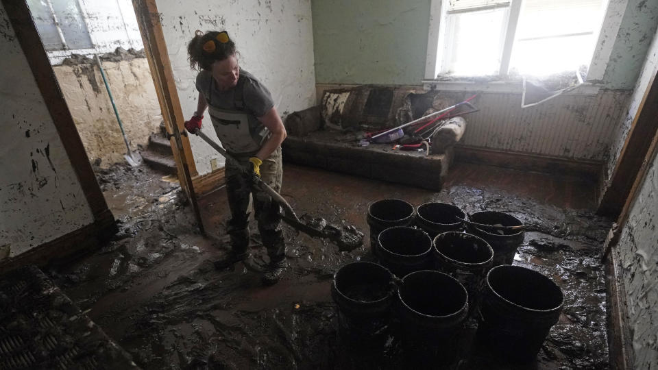 A volunteer cleans out a flooded basement Thursday, June 16, 2022, in Red Lodge, Mont. Yellowstone National Park officials say more than 10,000 visitors have been ordered out of the nation's oldest national park after unprecedented flooding tore through its northern half, washing out bridges and roads and sweeping an employee bunkhouse miles downstream. (AP Photo/Rick Bowmer)