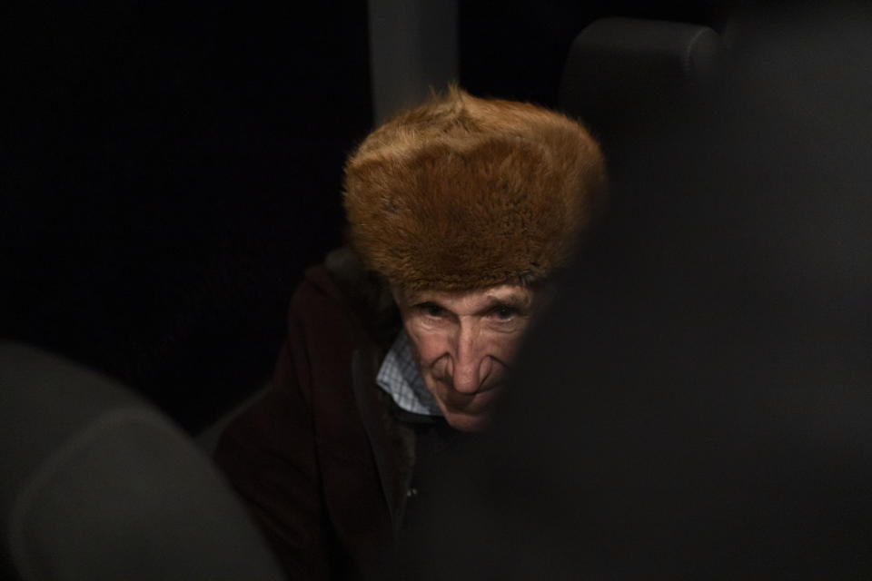 A man rides in a bus after crossing the border with Russia in Sumy region, Ukraine, Wednesday, Nov. 22, 2023. An average of 80-120 people return daily to Ukraine from territories held by Russia through an unofficial crossing point between the two countries amid a brutal war. Those who opt for this route endure painstaking searches from both sides and trek on foot for more than 2 kilometers through the grey zone. (AP Photo/Hanna Arhirova)