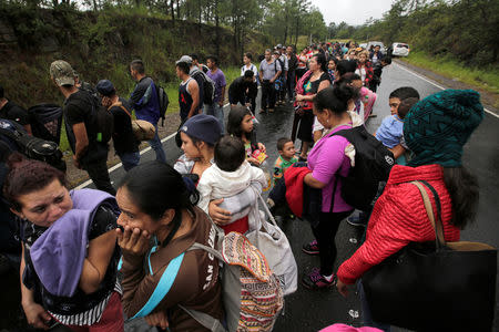 Honduran migrants queue to show their identification to the officials near to the Agua Caliente border, hoping to cross into Guatemala and join a caravan trying to reach the U.S, in the municipality of Ocotepeque, Honduras October 17, 2018. REUTERS/Jorge Cabrera